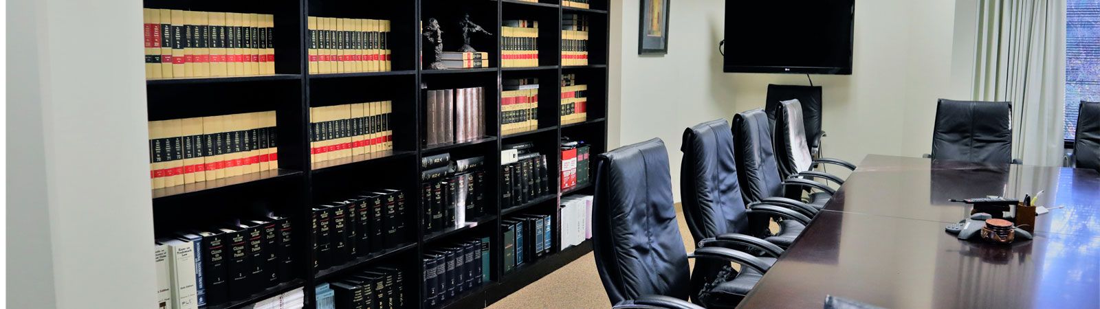 Law office conference room with built-in legal bookshelves and a long conference table